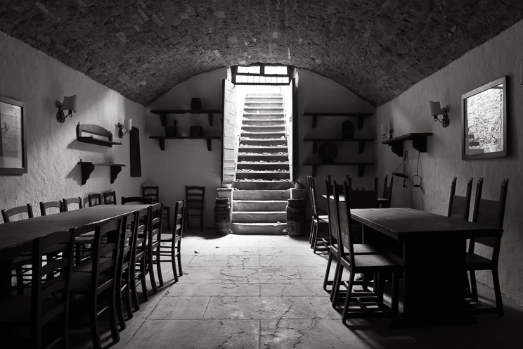 PORTFOLIO FOTOGRAFIA ARCHITETTURA ALTRI SPAZI: # Ulisse Albiati fotografo architettura interni: fotografia immobiliare antica cantina adattata a taverna. Decadente sala per ricevimenti, con tavoloni e sedie in legno e pavimento in cemento. Settecentesca villa di Melazzano a Greve in Chianti, Toscana.