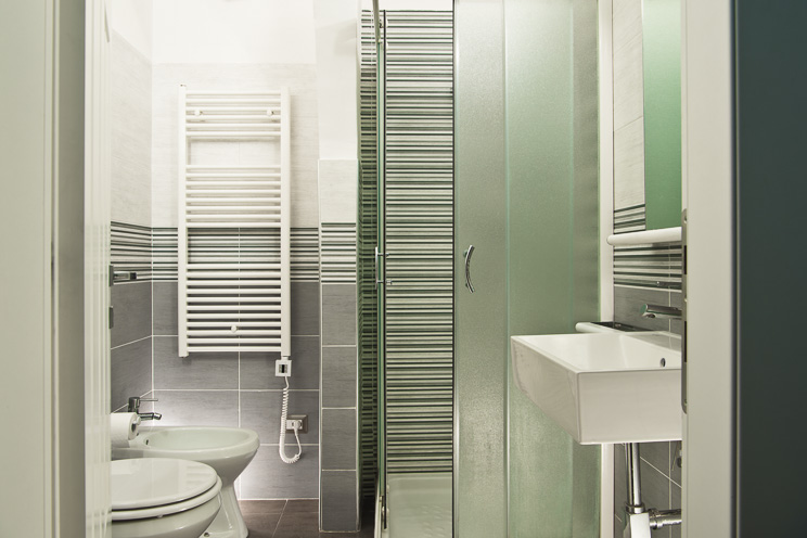 # Ulisse Albiati fotografo architettura interni: fotografia bagno di un bed and breakfast. Stile contemporaneo, con dominanti cromatiche di grigio e verde. Box doccia in vetro. B&B zona via dei Vellutini, nei pressi di piazza Pitti a Firenze, Toscana.