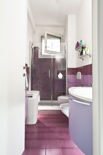 # Ulisse Albiati fotografo architettura interni: fotografia immobiliare bagno. Stile moderno con dominati cromatiche graduate magenta, lilla e violetto. Box doccia in vetro. Appartamento in zona Mercatale Val di Pesa, Toscana.