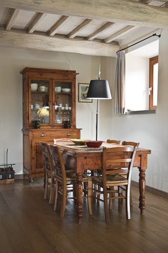 # Ulisse Albiati fotografo architettura interni: fotografia immobiliare sala da pranzo. Stile rustico ma elegante, con autentico parquet in legno. Tavolo, sedie e vetrina in massello. Soffitto con travi a vista dipinte di bianco. Casa colonica riconvertita in residenza borghese, zona Caldine, nei pressi di Fiesole in Toscana.