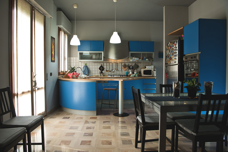 # Ulisse Albiati fotografo architettura interni: fotografia immobiliare cucina con funzione anche di sala da pranzo. Stile moderno, con mobili blu e pavimento in marmo beige. Villetta in zona Cerreto Guidi, Toscana.