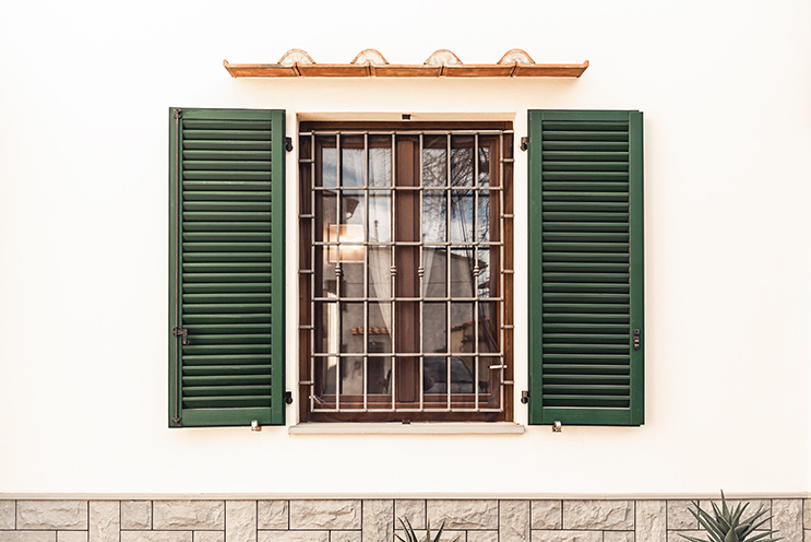 # Ulisse Albiati fotografo architettura esterni: fotografia immobiliare, dettaglio finestra con persiane e inferriata, facciata di edificio nell'antico e originario nucleo abitativo di Peretola. Via della Stazione delle Cascine a Firenze, Toscana.